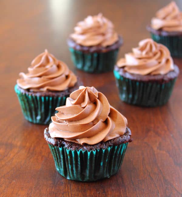 Chocolate Zucchini Cupcakes with Cream Cheese Frosting on a wood table