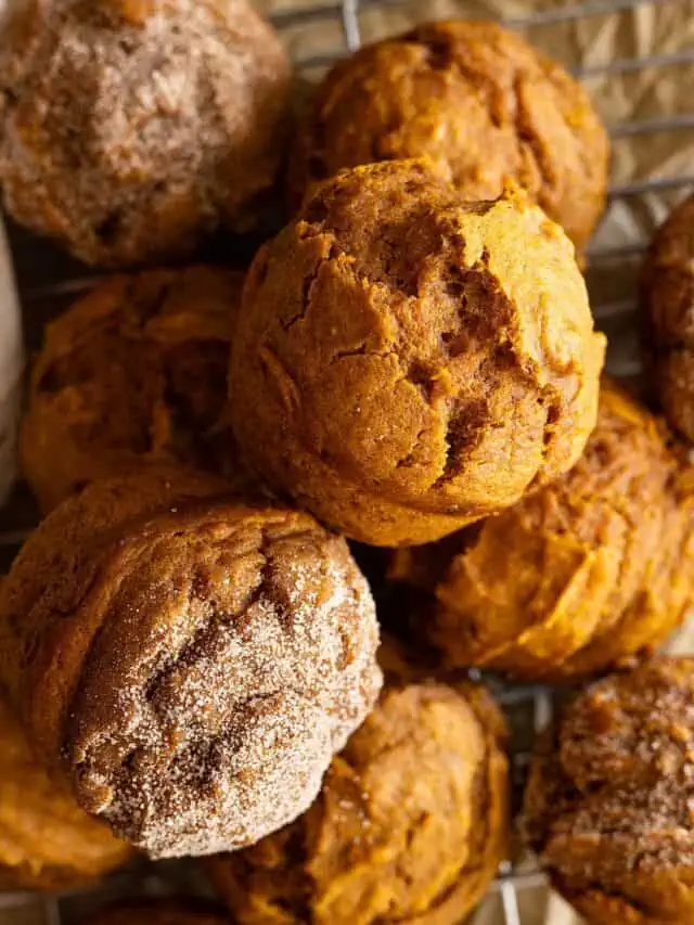 Overhead view of several pumpkin muffins piled together.