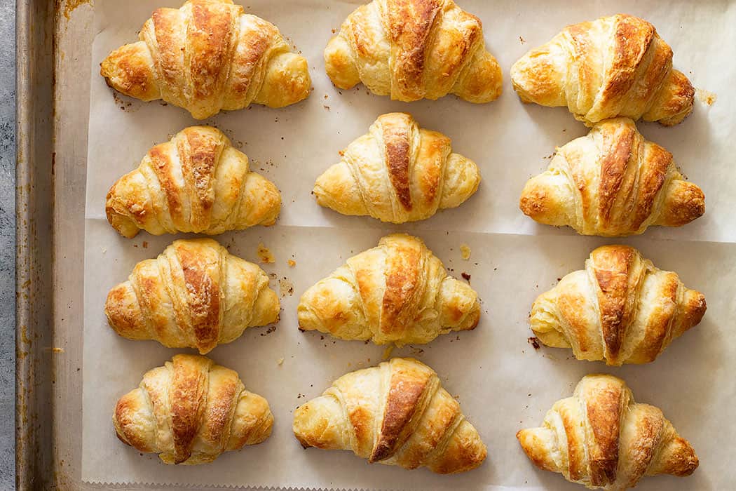 A top down view of crescent rolls on a baking sheet.