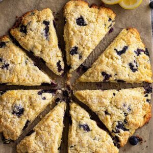 Top down view of lemon blueberry scones with slices of lemons for garnish.