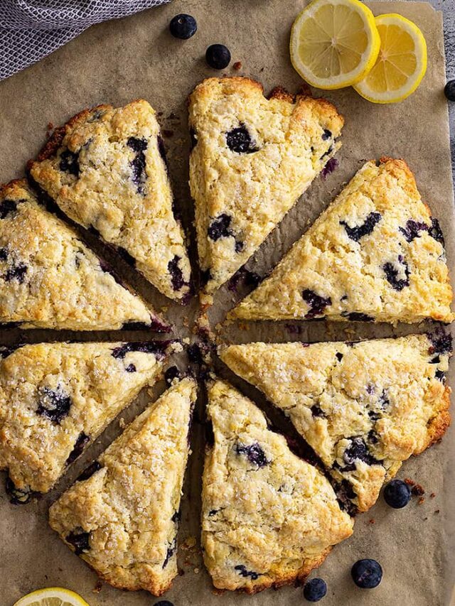 Top down view of lemon blueberry scones with slices of lemons for garnish.