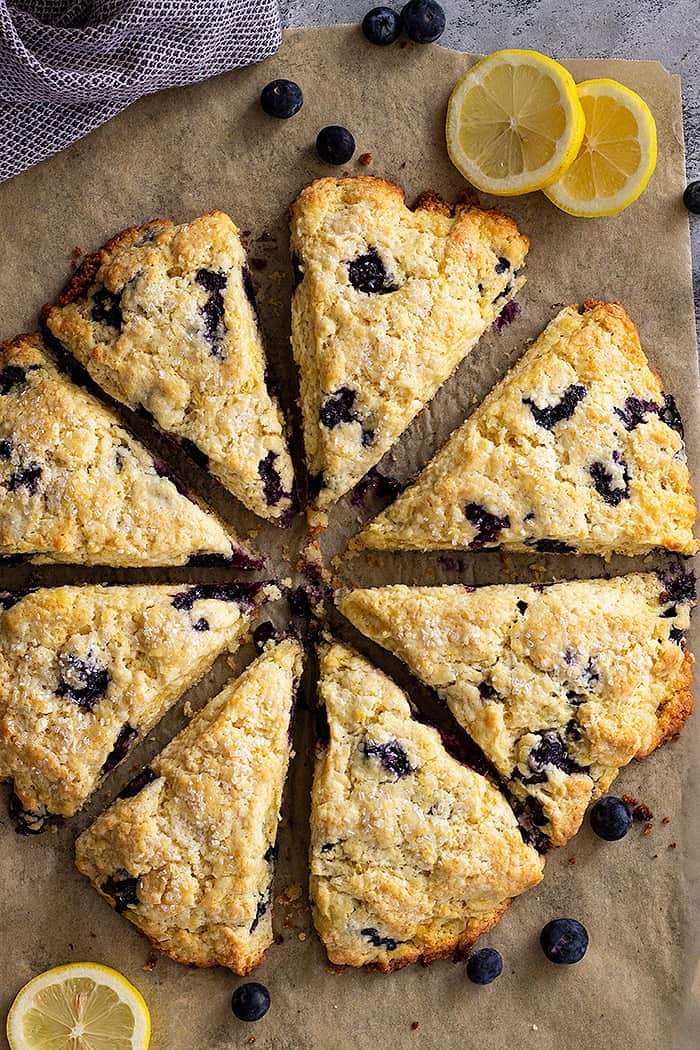 Top down view of lemon blueberry scones with slices of lemons for garnish.