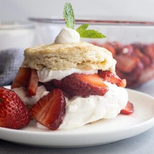 Strawberry Shortcake on a white plate. Juicy strawberries and freshly whipped cream.