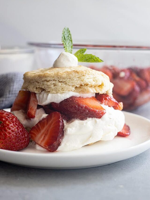 Strawberry Shortcake on a white plate. Juicy strawberries and freshly whipped cream.