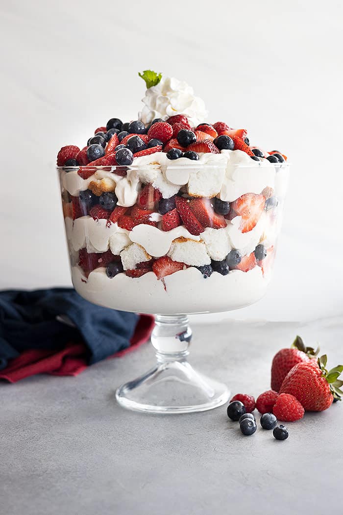 A trifle bowl filled with angel food cake, coconut cheesecake filling, strawberries, blueberries, and raspberries. All in pretty layers. 