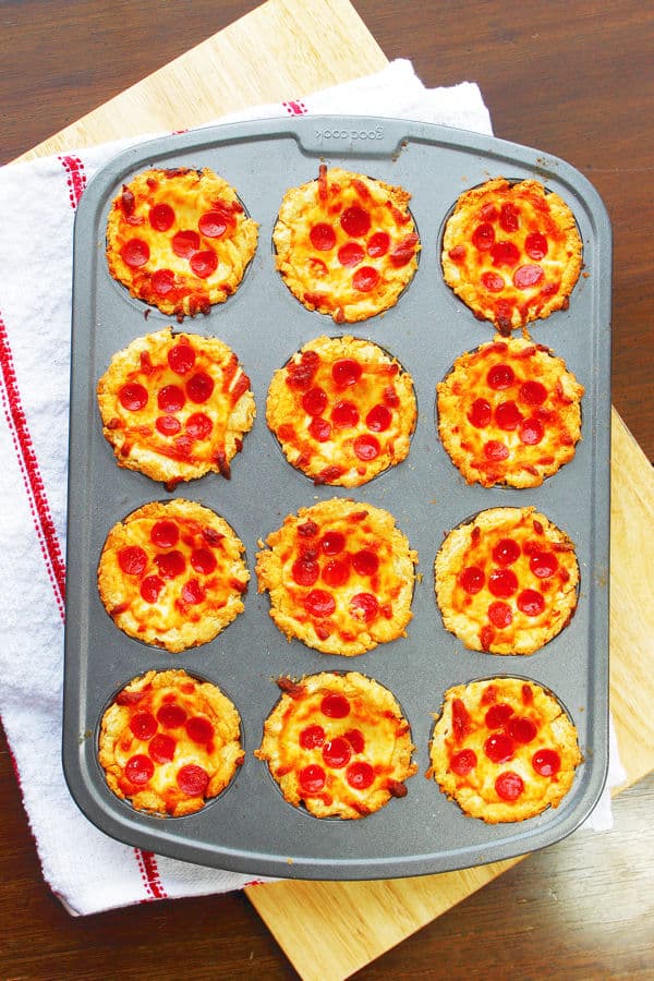 Mini Deep Dish Pizzas in a muffin tin with pepperoni on top