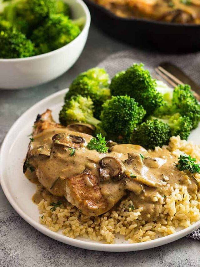 White plate with broccoli, rice, chicken, and a mushroom cream sauce drizzled on top