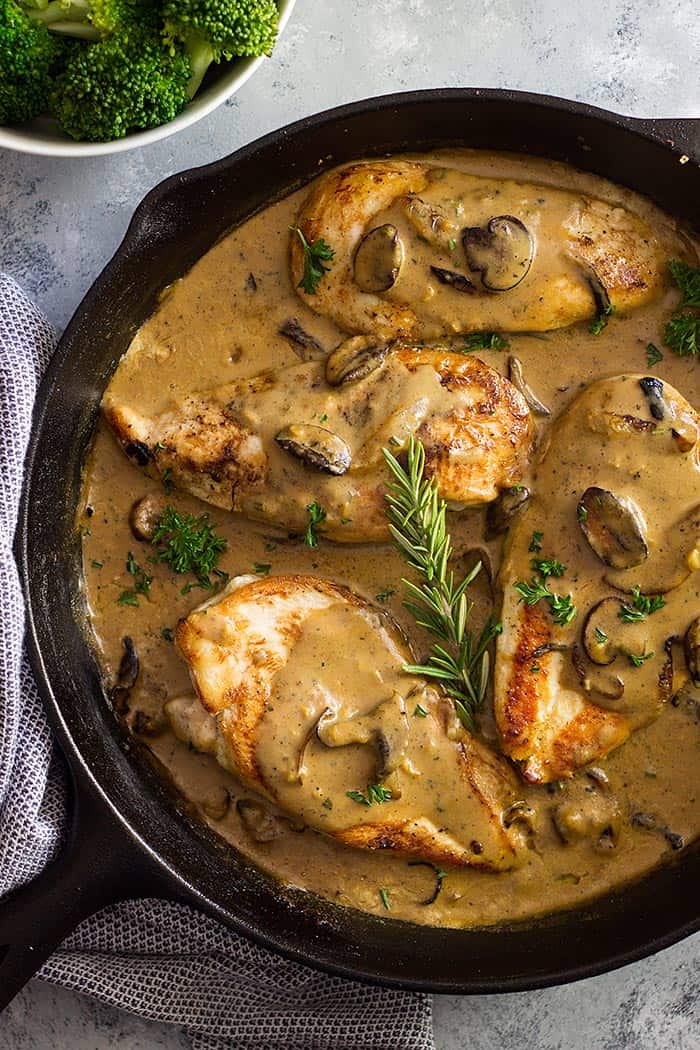 chicken in mushroom cream sauce with fresh rosemary in black skillet