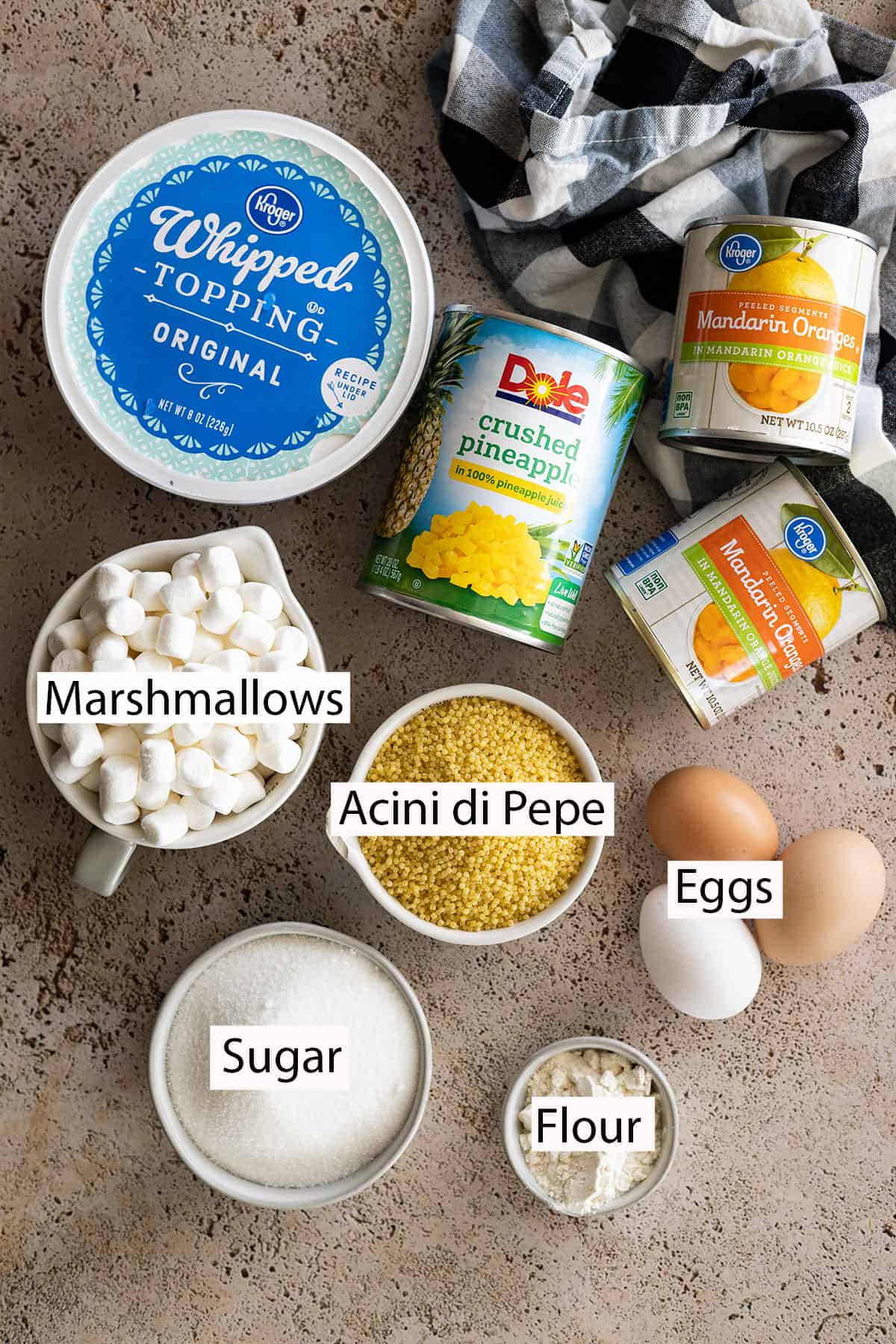 Ingredients: whipped topping, crushed pineapple, mandarin oranges, miniature marshmallows, acini di pepe, eggs, sugar, flour.