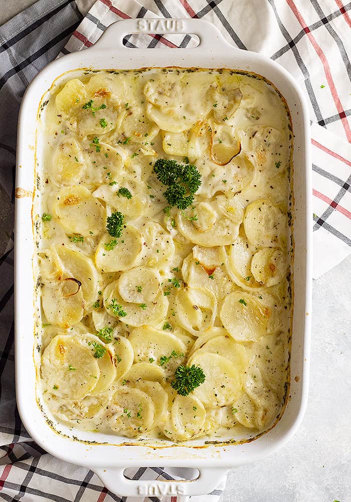 Top down view of scalloped potatoes garnished with fresh parsley.