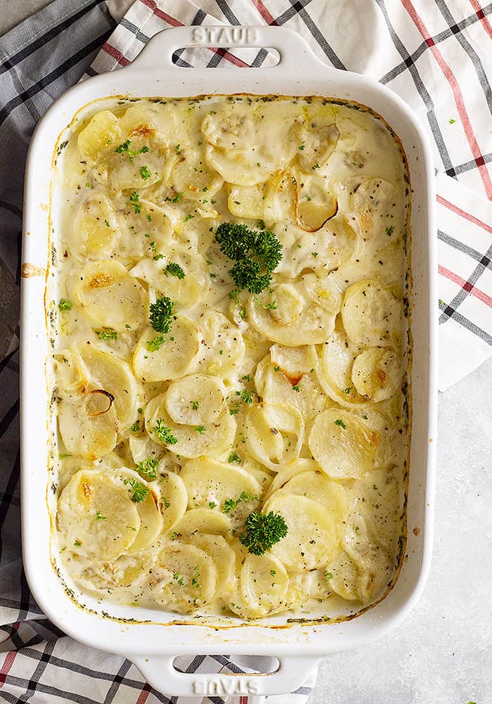 Top down view of scalloped potatoes garnished with fresh parsley. 