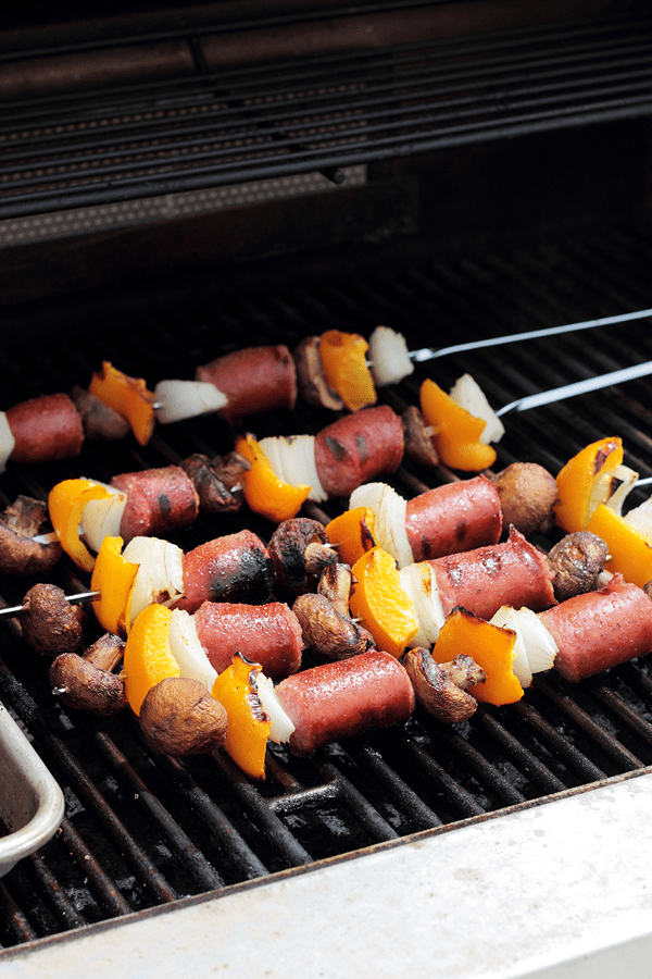 sausage and veggie kabobs on skewers on a grill