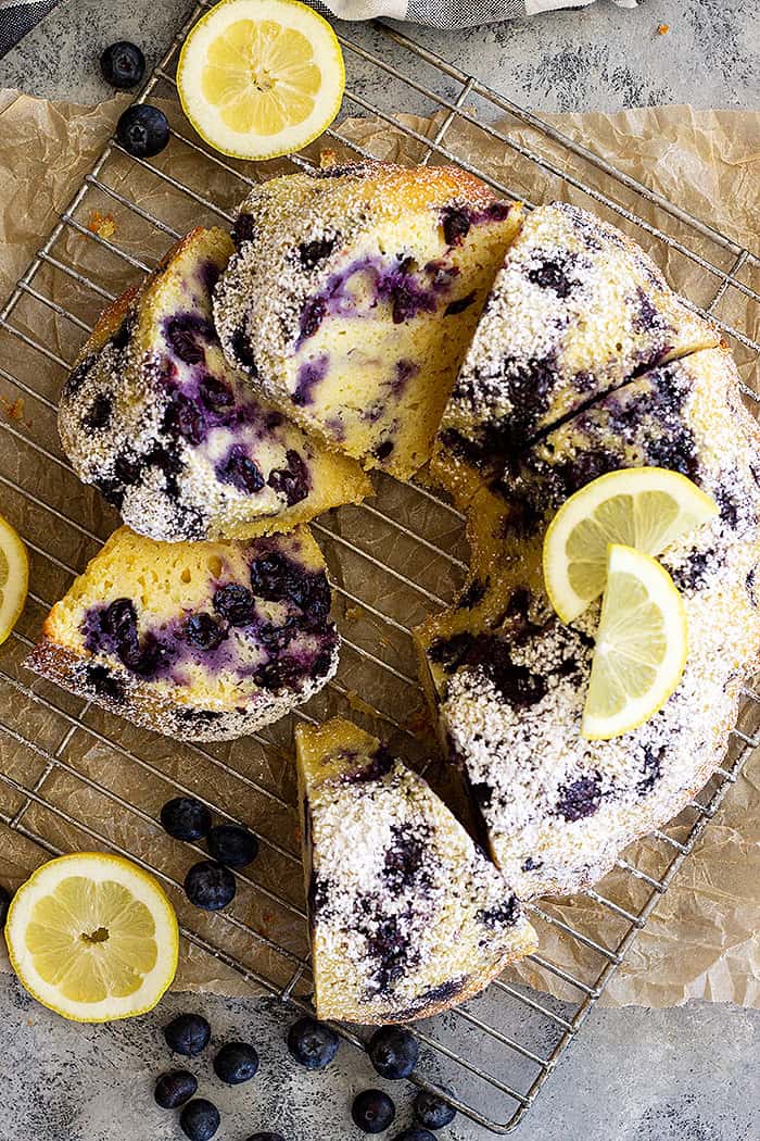 Top down view of pieces of cake cut and decorated with cut lemons and extra blueberries.