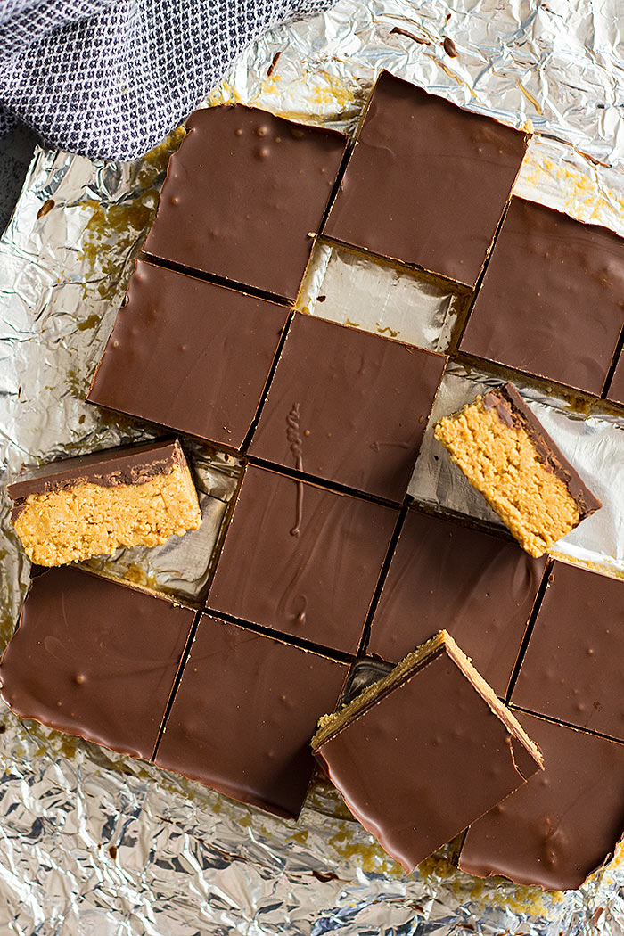 A top down view of no bake chocolate peanut butter bars with a few turned on their side. 