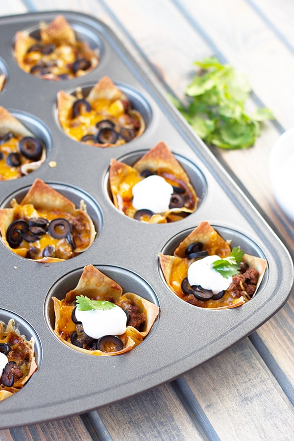 Beef Enchilada Cups- an easy and oh so tasty game day appetizer. Filled with seasoned beef, black beans, cheddar, black olives and topped with creamy sour cream. | Countryside Cravings