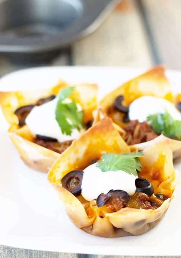 Beef Enchilada Cups- an easy and oh so tasty game day appetizer. Filled with seasoned beef, black beans, cheddar, black olives and topped with creamy sour cream. | Countryside Cravings