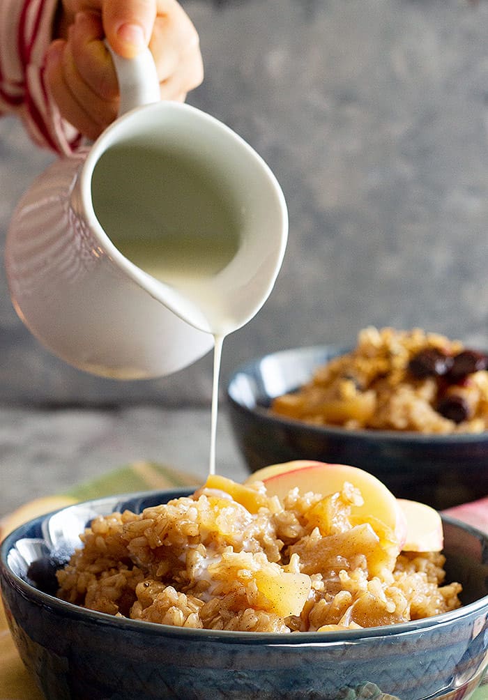 Milk being poured over Slow Cooker Cinnamon Apple Breakfast Rice.