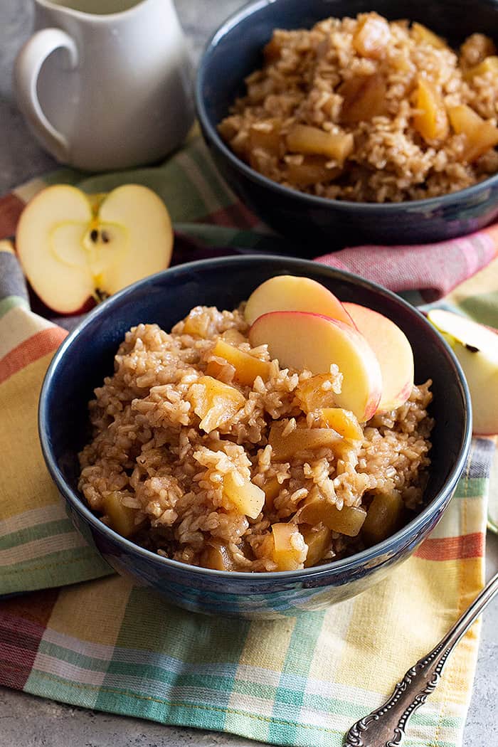 Two bowls of warm and comforting slow cooker cinnamon apple breakfast rice.