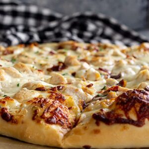 Close up of pizza crust showing the lightly browned melty cheese.