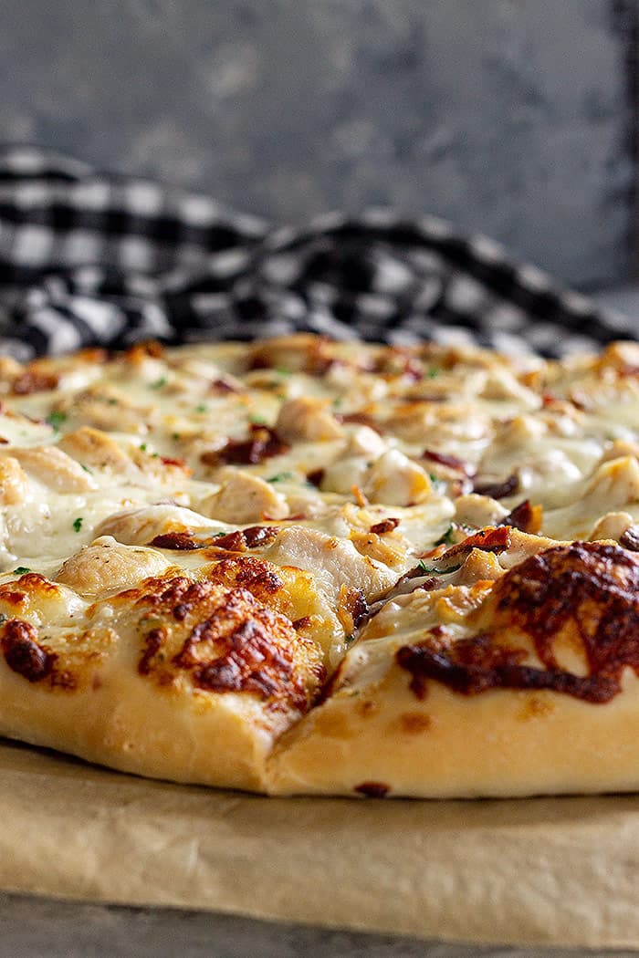 Close up of pizza crust showing the lightly browned melty cheese. 