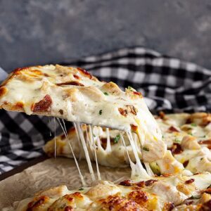 Slice of pizza with an awesome cheese pull.