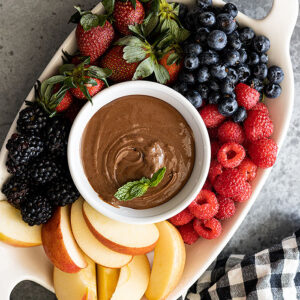 Overhead view of fruit dip on a platter with fresh fruit all around.