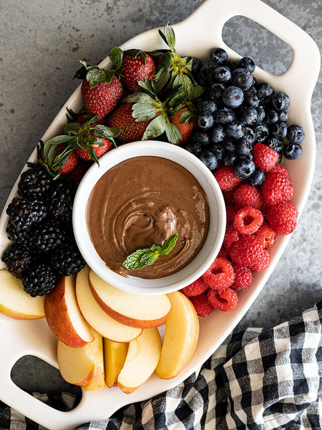 Overhead view of fruit dip on a platter with fresh fruit all around.