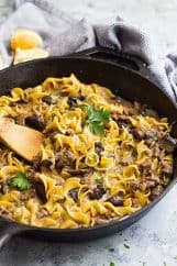 One pot hamburger stroganoff in a pan with a wooden spoon in it.