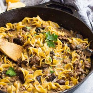 One pot hamburger stroganoff in a pan with a wooden spoon in it.