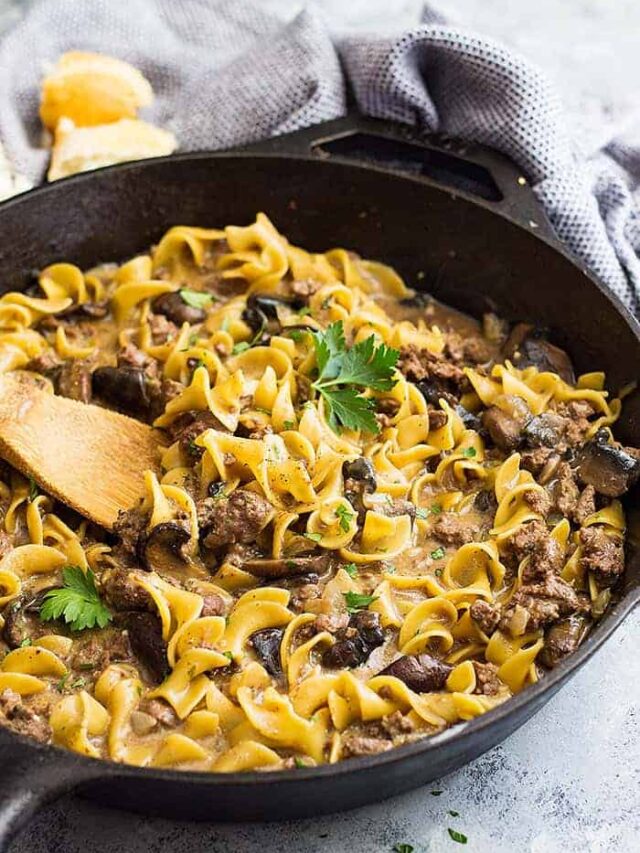 One pot hamburger stroganoff in a pan with a wooden spoon in it.