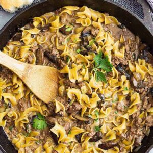A top down view of one pot hamburger stroganoff in a pan with a spoon.
