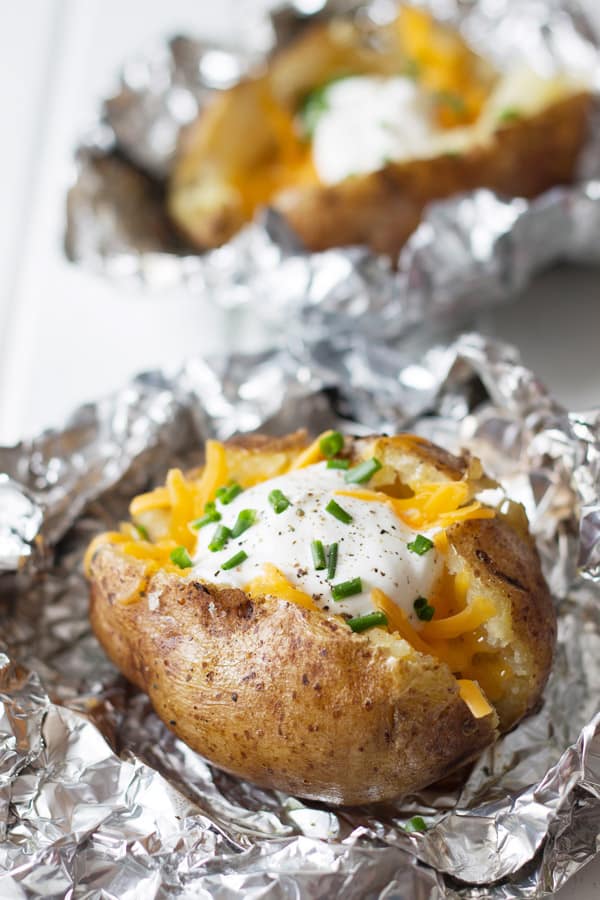 slow cooker baked potatoes with sour cream and cheese in foil