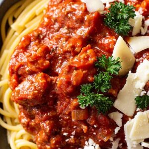 Close up of spaghetti sauce on pasta and topped with cheese.