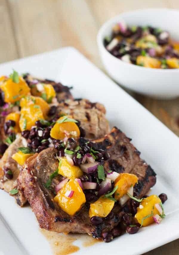 Citrus Marinated Pork Chops with Mango Black Bean Salsa -a juicy marinated pork chop grilled to perfection. Topped with a sweet and savory mango salsa! | www.countrysidecravings.com