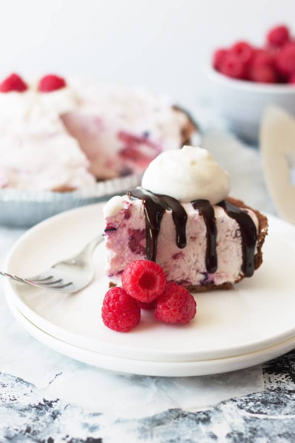 creamy frozen triple berry cheesecake topped with hot fudge and whipped cream