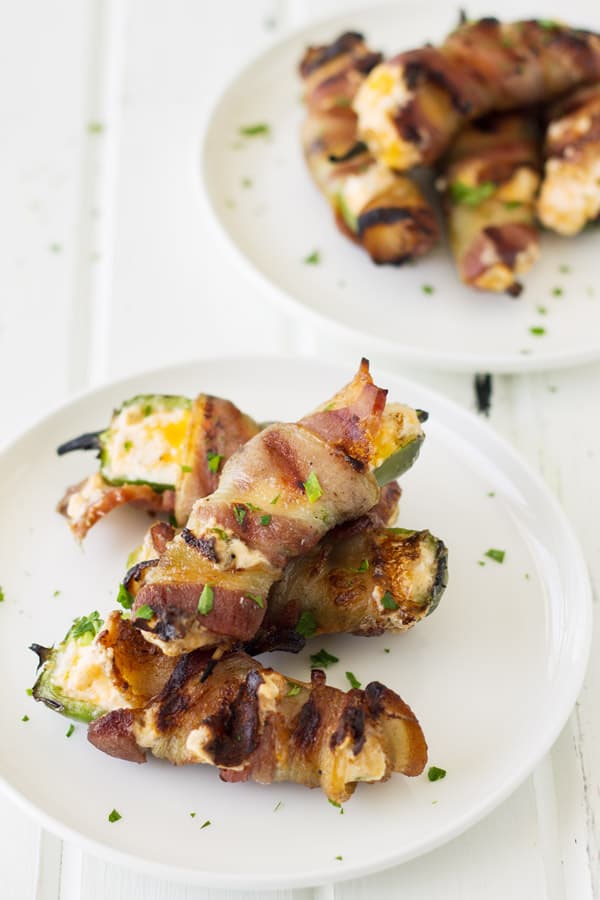 Grilled Jalapeno Poppers with a creamy cheese mixture and bacon on a white plate