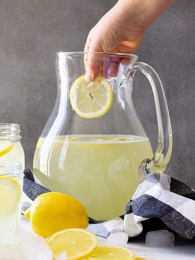 Dropping a cut lemon into the lemonade.