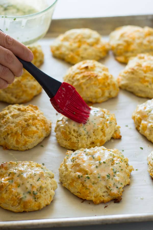adding melted butter to cheddar biscuits