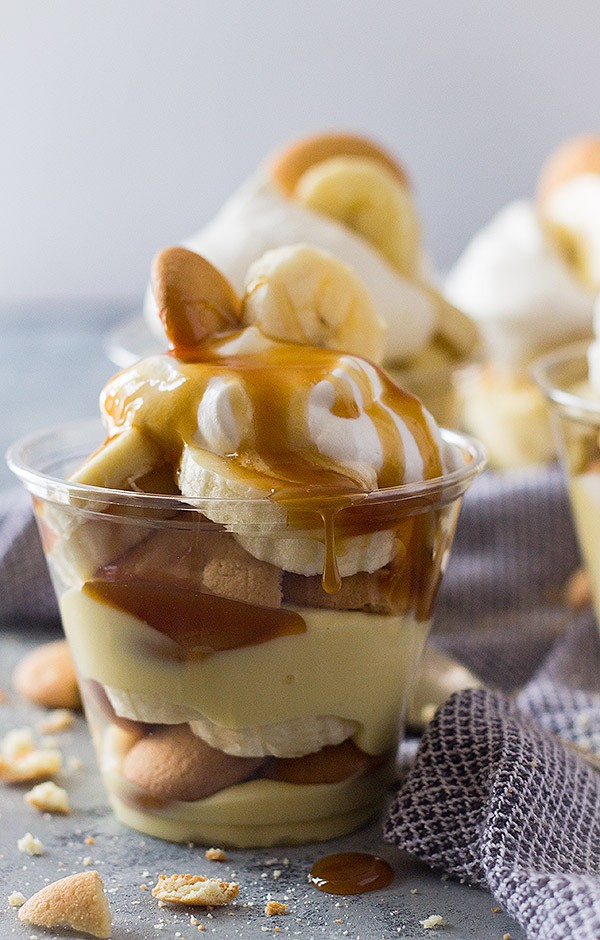 Plastic cup with layers of vanilla wafers, pudding, bananas, and whipped cream. 