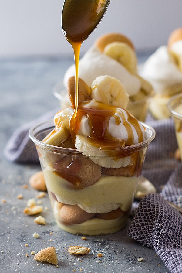 Spoon drizzling caramel onto homemade banana pudding cups. 