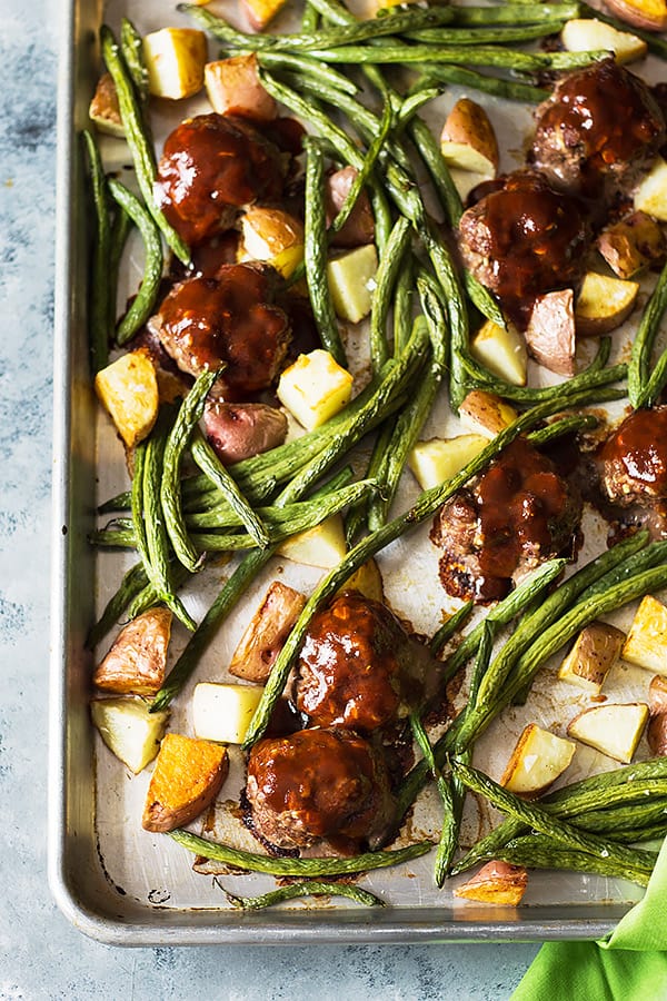 a sheet pan full of bbq meatballs, green beans, and roasted potatoes