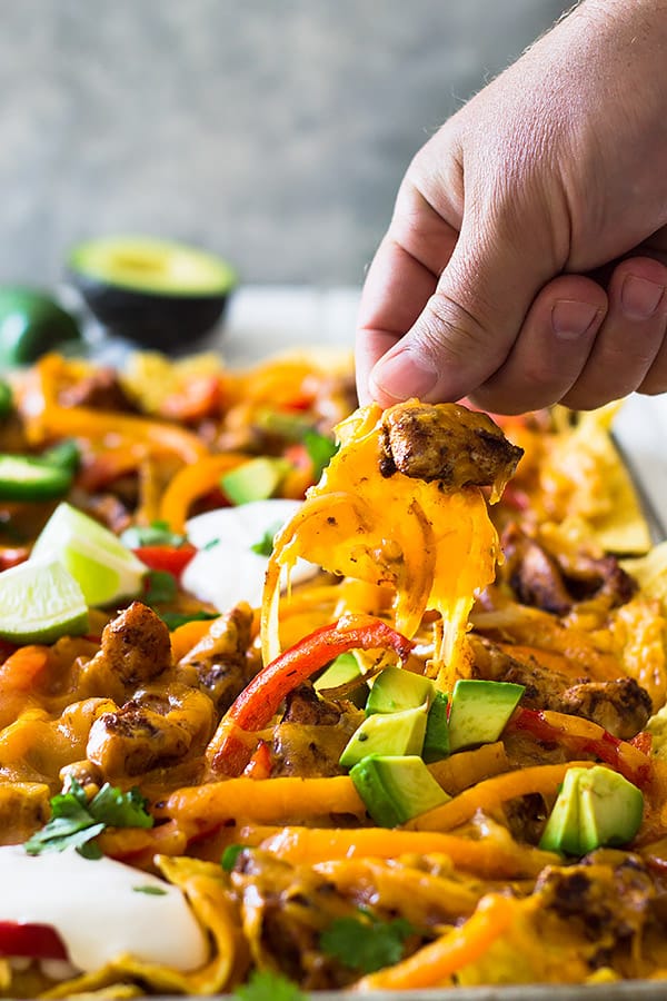 This Sheet Pan Chicken Fajita Nachos is a great game day appetizer for a crowd! Filled with seasoned chicken and vegetables and lots of cheese! | www.countrysidecravings.com