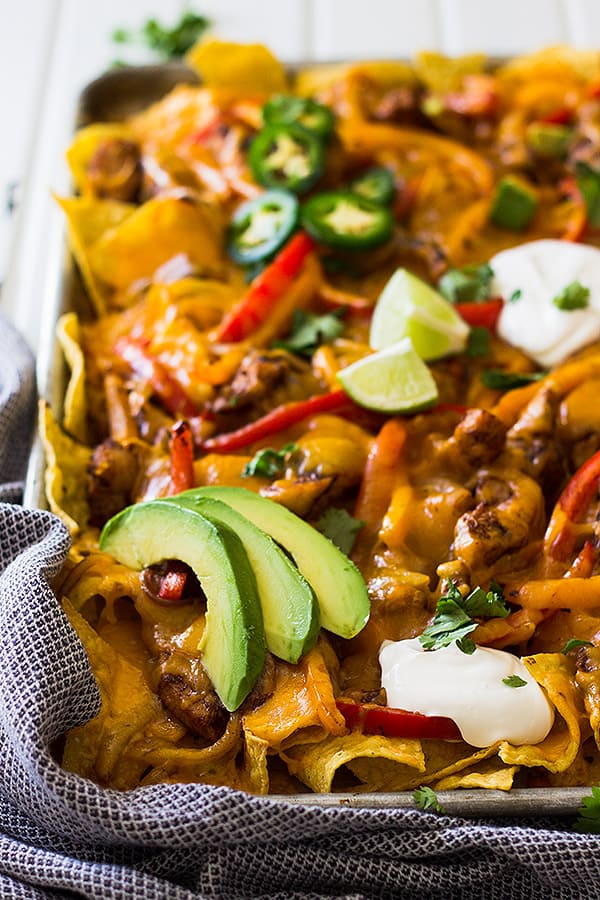 This Sheet Pan Chicken Fajita Nachos is a great game day appetizer for a crowd! Filled with seasoned chicken and vegetables and lots of cheese! | www.countrysidecravings.com