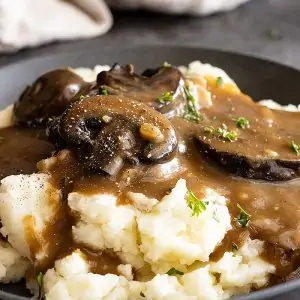 Close up of gravy over mashed potatoes.