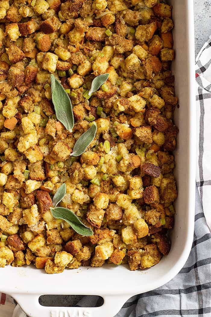 Top down view of freshly baked homemade herb stuffing garnished with fresh sage leaves.