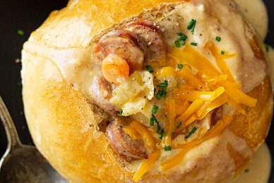 Top down view of Creamy Cajun Potato Soup in a bread bowl garnished with chives.