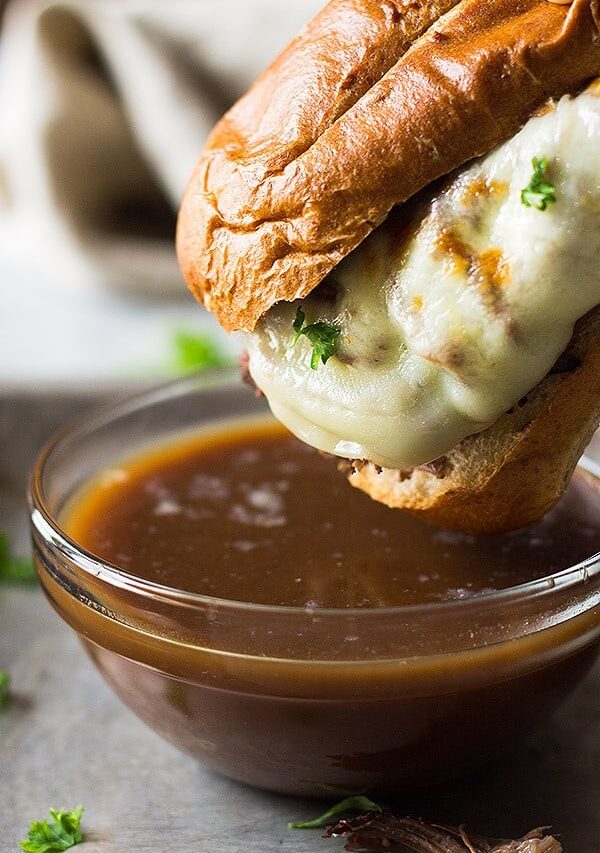 An easy recipe for Slow Cooker French Dip Sandwiches! These are filled with tender and flavorful beef, melty cheese and a beefy au jus for dipping! | www.countrysidecravings.com