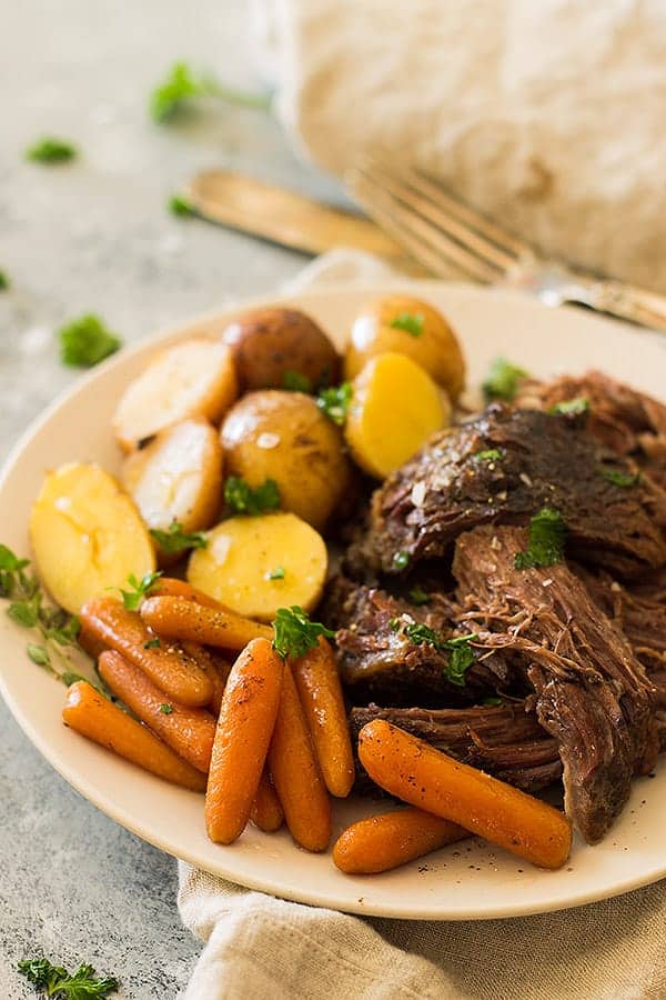 Crazy tender, melt in your mouth slow cooker pot roast with carrots and potatoes. This super easy meal requires little prep and the crockpot does all the work! | www.countrysidecravings.com