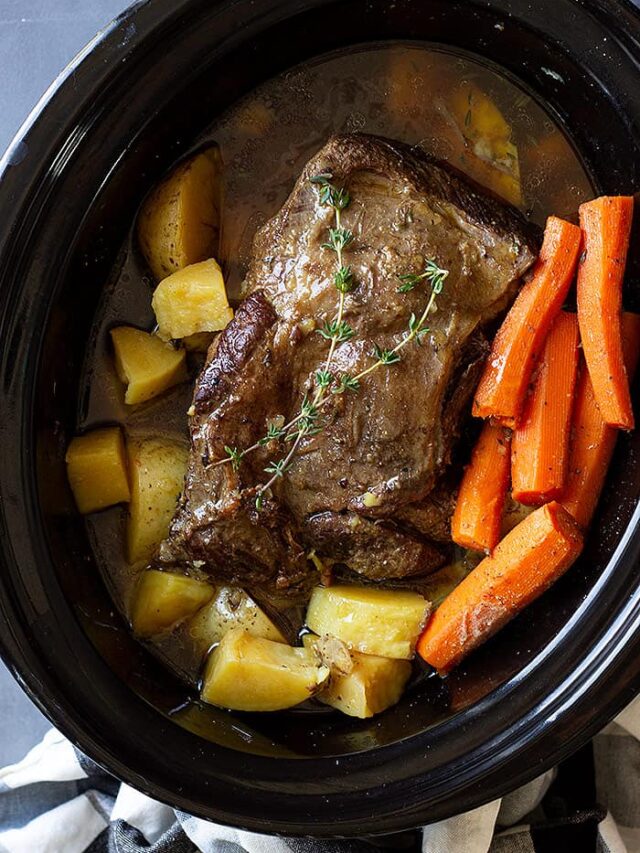 pot roast in slow cooker with carrots and potatoes.