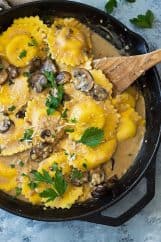 This Cheese Ravioli in Creamy Mushroom Sauce is made easy using store bought ravioli and made extra decadent with a simple garlic mushroom cream sauce! | www.countrysidecravings.com